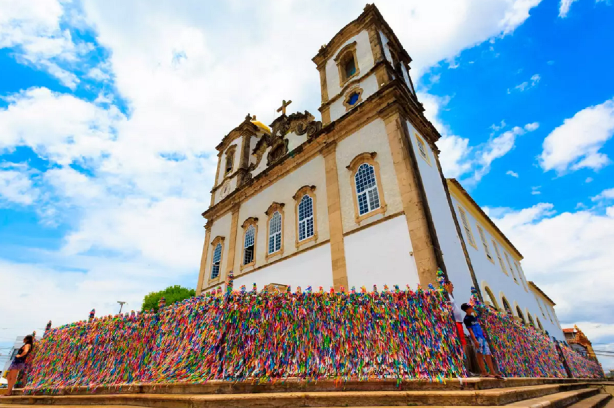 Igreja do Bonfim: fé, tradição e beleza em Salvador 1 Fachada da Igreja do Bonfim em Salvador com o tradicional gradil coberto por fitinhas coloridas de promessas
