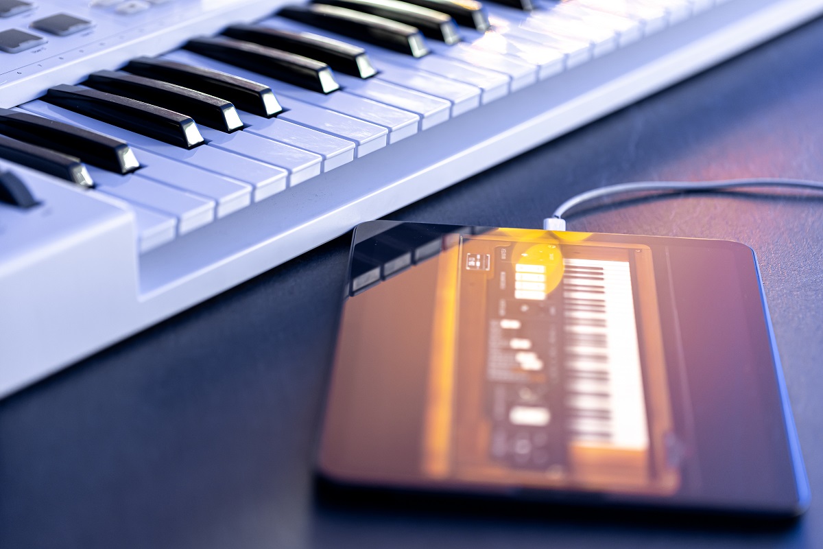Modelos de pianos digitais híbridos 1 Chaves musicais e um tablet em cima da mesa